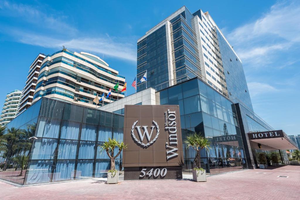 Foto da fachada de um hotel da Rede Windsor na Barra da Tijuca. Ao fundo, outros prédios.