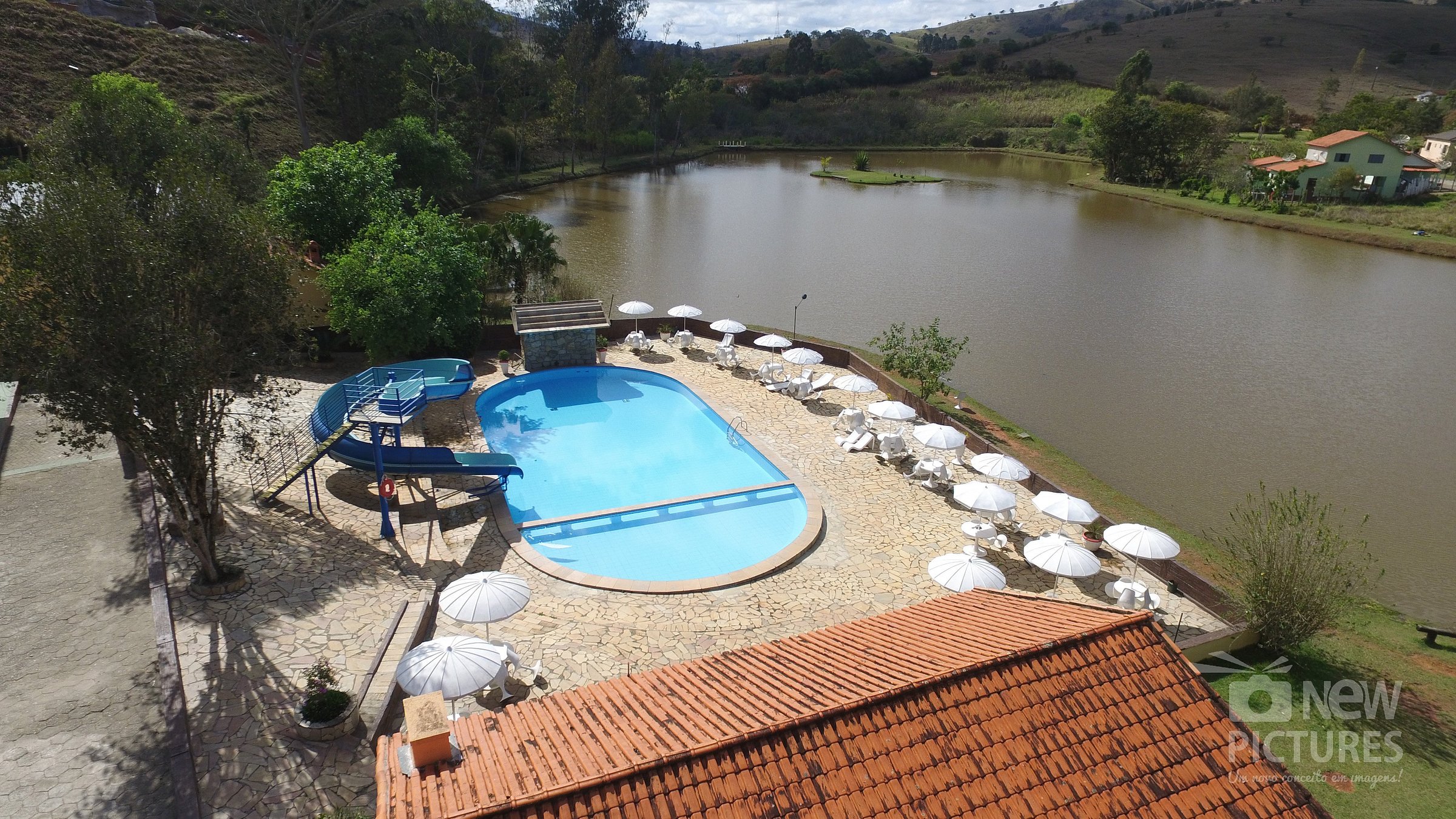 Imagem com vista da piscina e do lago ao redor do Hotel Fazenda Vista Alegre.