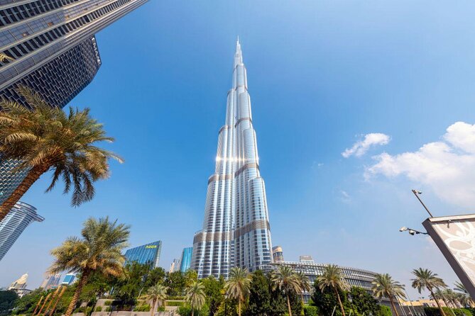 Imagem do Burj Khalifa, um arranha-céu no centro de Dubai. Ao redor, outros prédios e um céu azul