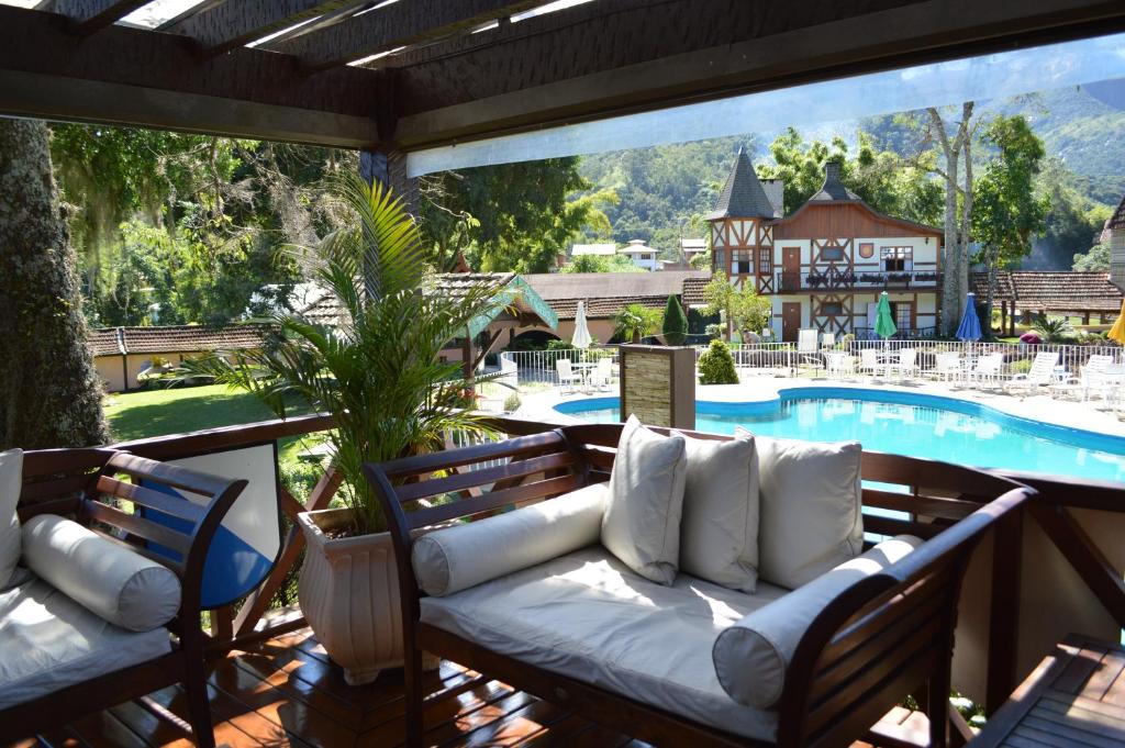 imagem de um deck na beira da piscina com cadeiras dentro do resort Le Canton Village