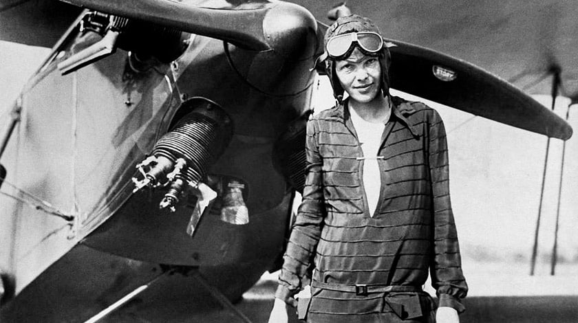 foto preto e branca de uma mulher na frente de uma aeronave vestida de piloto