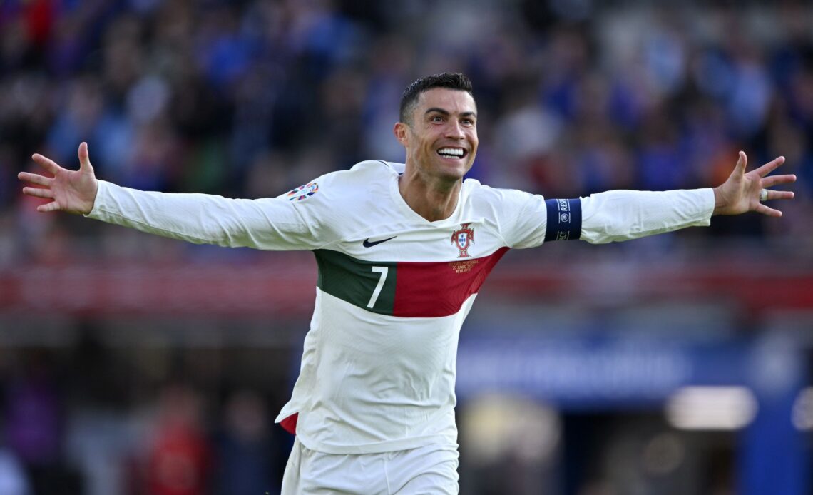 Cristiano Ronaldo comemorando um gol com os braços abertos, vestindo a camisa da seleção portuguesa.