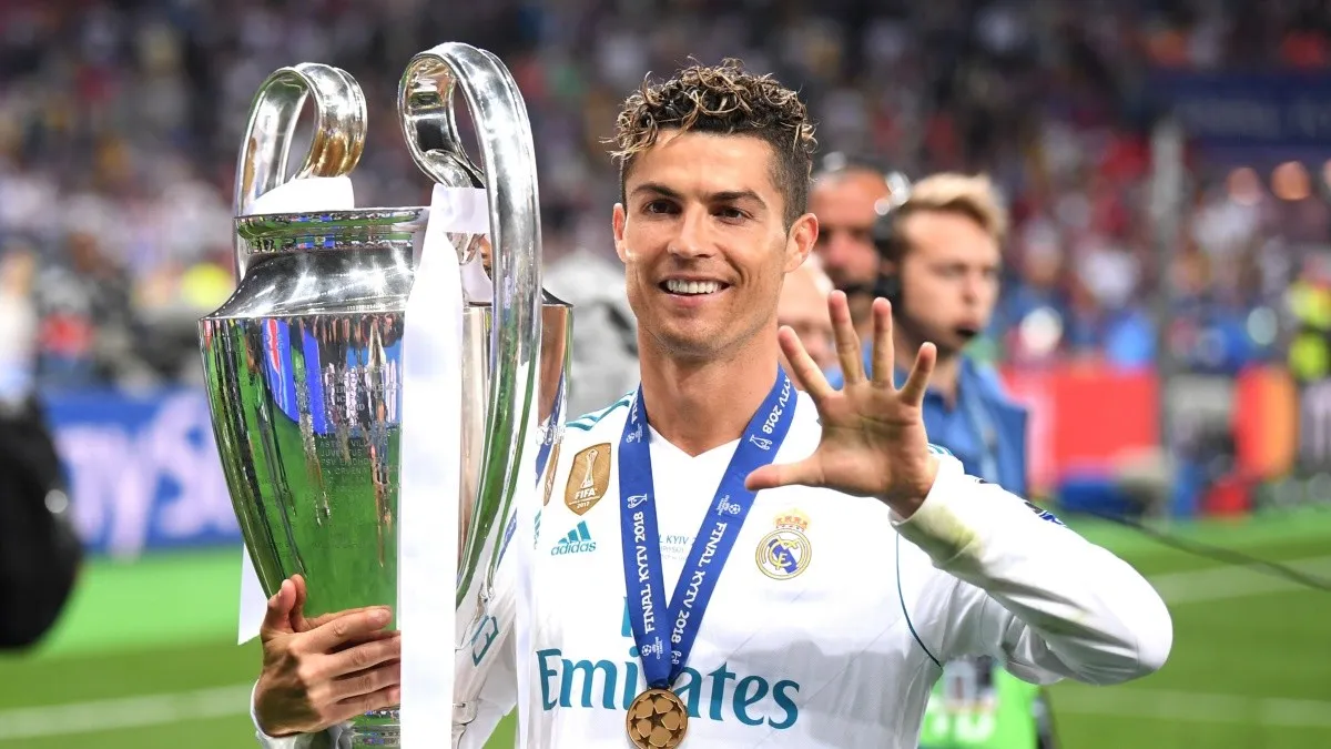 Cristiano Ronaldo segurando o troféu da UEFA Champions League e mostrando cinco dedos.