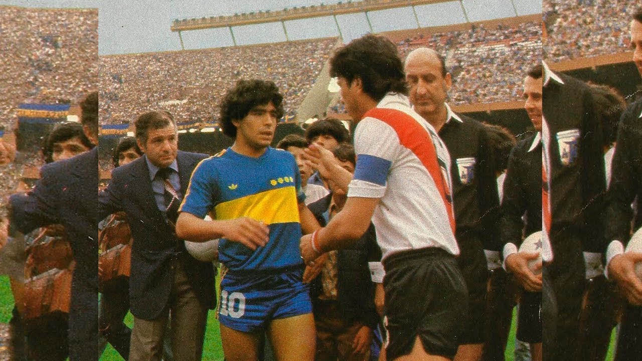 Jogadores de Boca Juniors e River Plate se cumprimentando antes de um clássico argentino, com Diego Maradona em destaque.