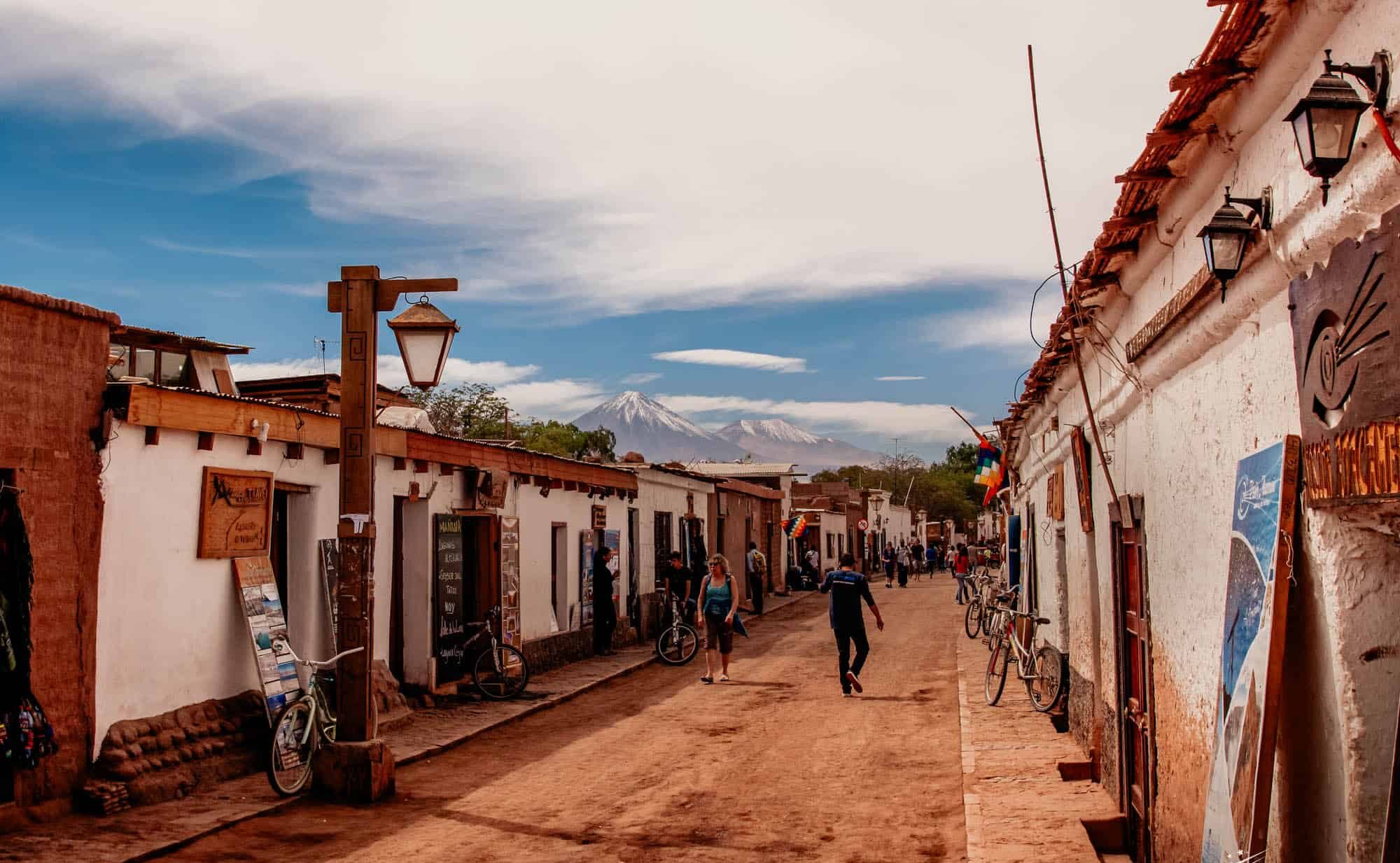 Rua em San Pedro de Atacama com vista para montanhas ao fundo