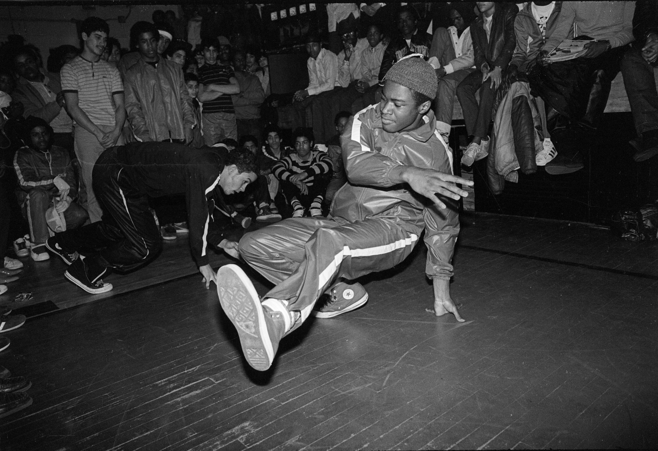 Dançarinos de breakdance em uma batalha no Bronx, com uma multidão assistindo atentamente.