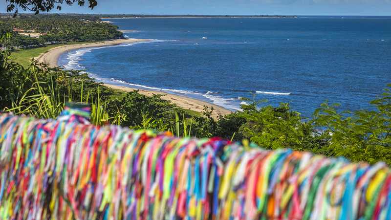 Vista panorâmica da praia de Trancoso com fitas coloridas em primeiro plano.