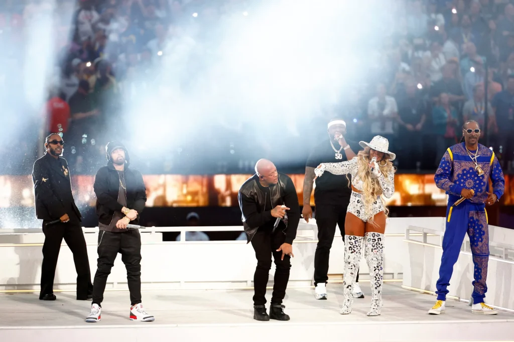 Artistas Kendrick Lamar, Eminem, 50 Cent, Mary J. Blige, Snoop Dogg e Dr. Dre performando no show do intervalo do Super Bowl 2022, um evento de grande destaque no turismo esportivo e musical.