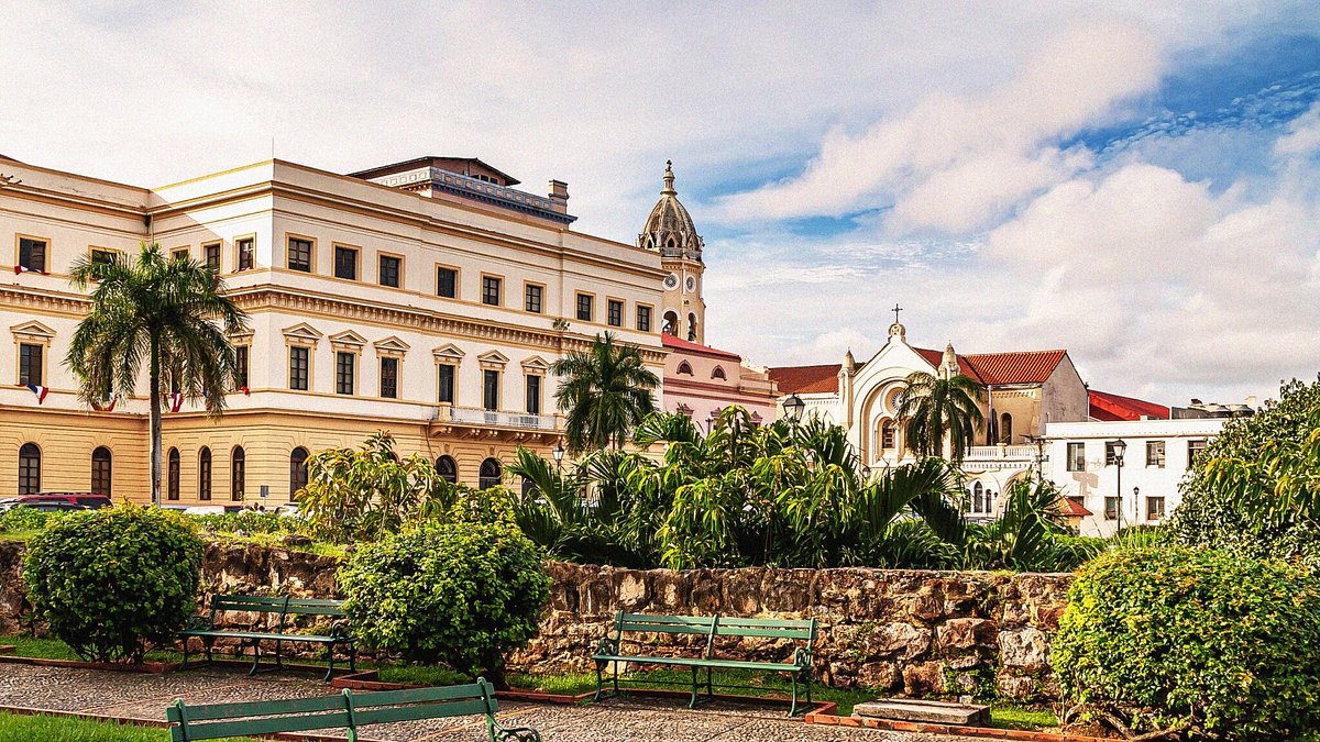 Edifícios históricos no bairro Casco Viejo, na Cidade do Panamá, com jardins e bancos em primeiro plano.