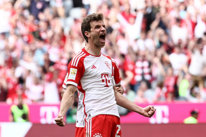 Jogador de futebol do Bayern de Munique comemorando um gol em um estádio lotado.