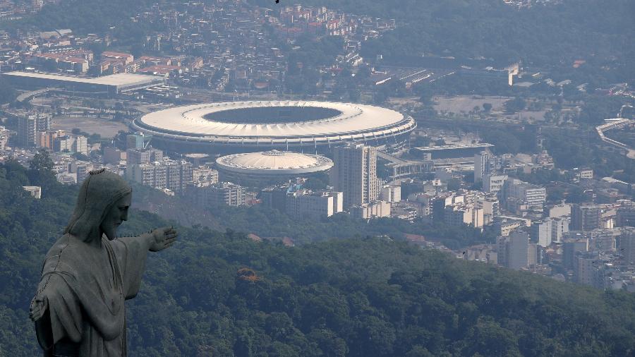 Vista aérea do Estádio do Maracanã, o Templo do Futebol, no Rio de Janeiro, com a estátua do Cristo Redentor em primeiro plano.