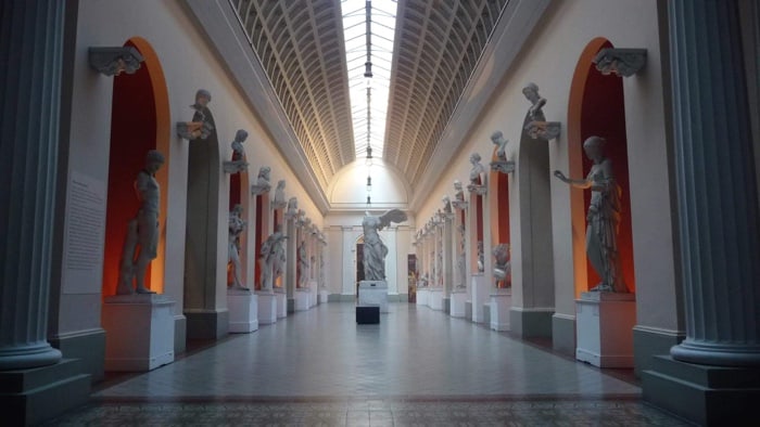 Galeria de esculturas clássicas no Museu Nacional de Belas Artes (MNBA), no Rio de Janeiro, iluminada por luz natural.