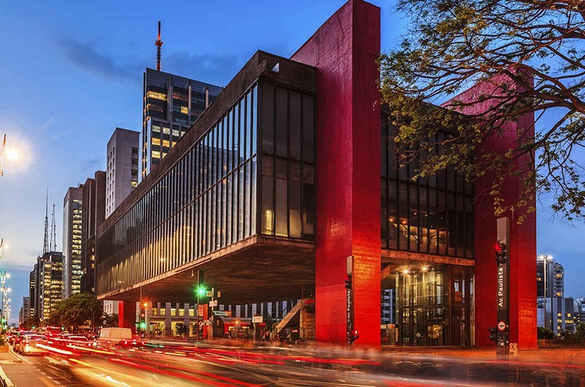 Fachada iluminada do Museu de Arte de São Paulo (MASP) na Avenida Paulista, em São Paulo, durante o entardecer.