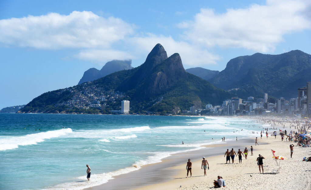 Vista da Praia de Ipanema no Rio de Janeiro durante o inverno, com turistas aproveitando o dia ensolarado. Rio de Janeiro, turismo, inverno.