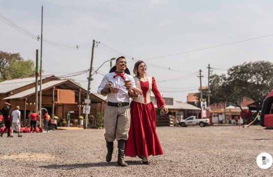 Casal em trajes típicos gaúchos em feira tradicional na Serra Gaúcha, simbolizando a retomada do turismo nacional no Rio Grande do Sul.