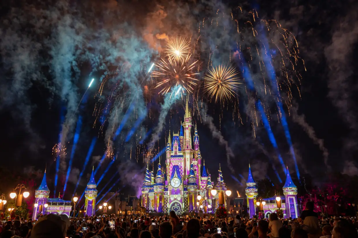 Castelo da Disney iluminado por fogos de artifício durante a noite no parque Magic Kingdom, em Orlando.