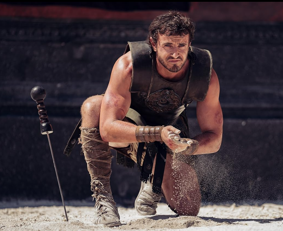 Ator caracterizado como gladiador ajoelhado na arena durante gravações de Gladiador 2, na Ilha de Malta.