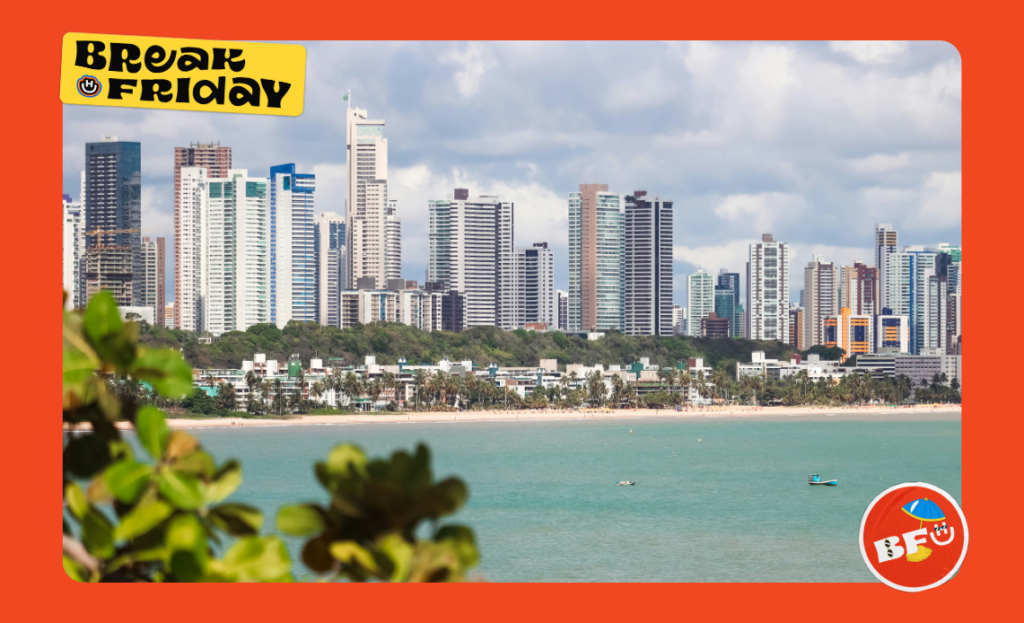 Skyline de João Pessoa, com prédios modernos ao fundo e a praia com mar verde ao centro, representando o charme do Nordeste brasileiro.