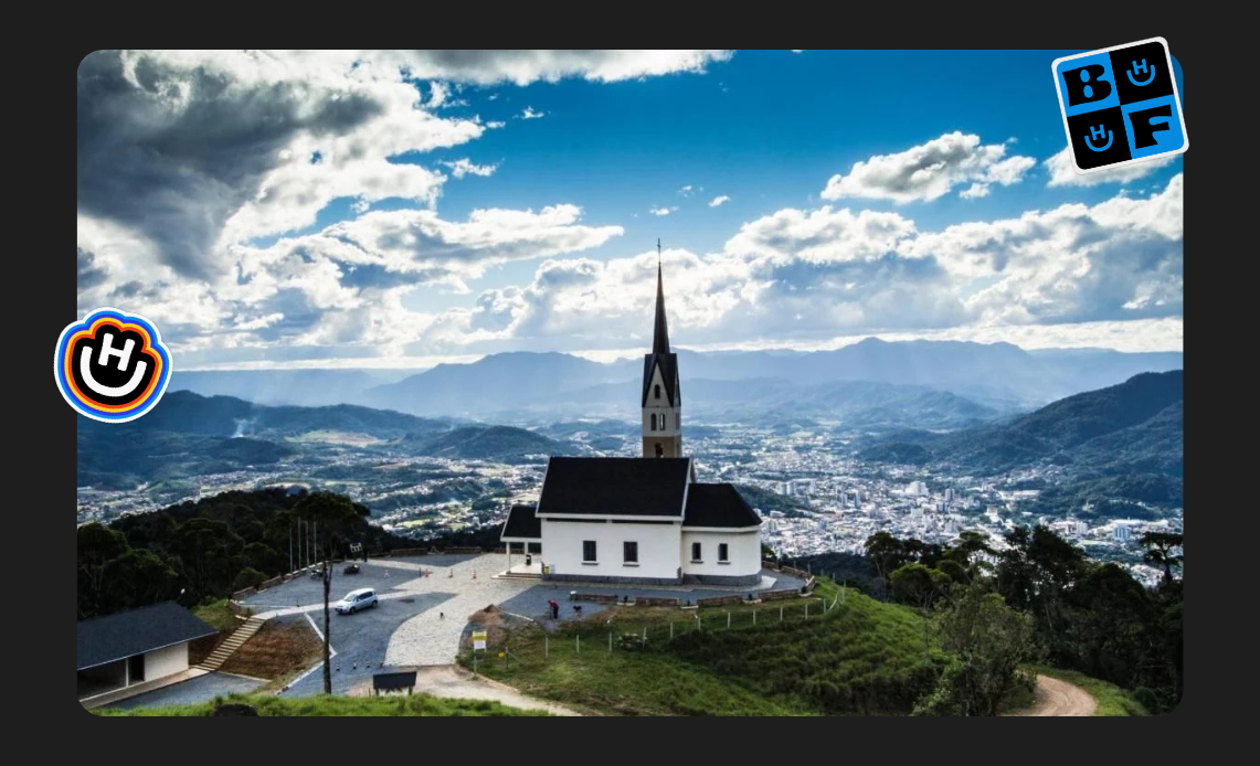 Vista panorâmica de Jaraguá do Sul, Santa Catarina, destacando uma igreja histórica em meio às montanhas.