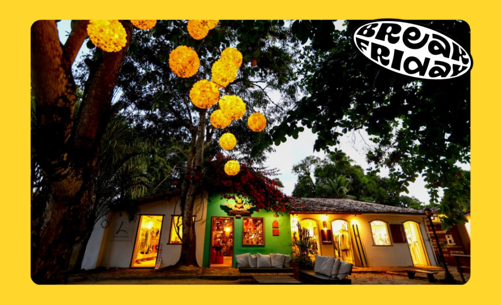 Fachada iluminada de loja em Trancoso, Porto Seguro, Bahia, à noite, com decoração suspensa de luzes, destacando a atmosfera charmosa do vilarejo.