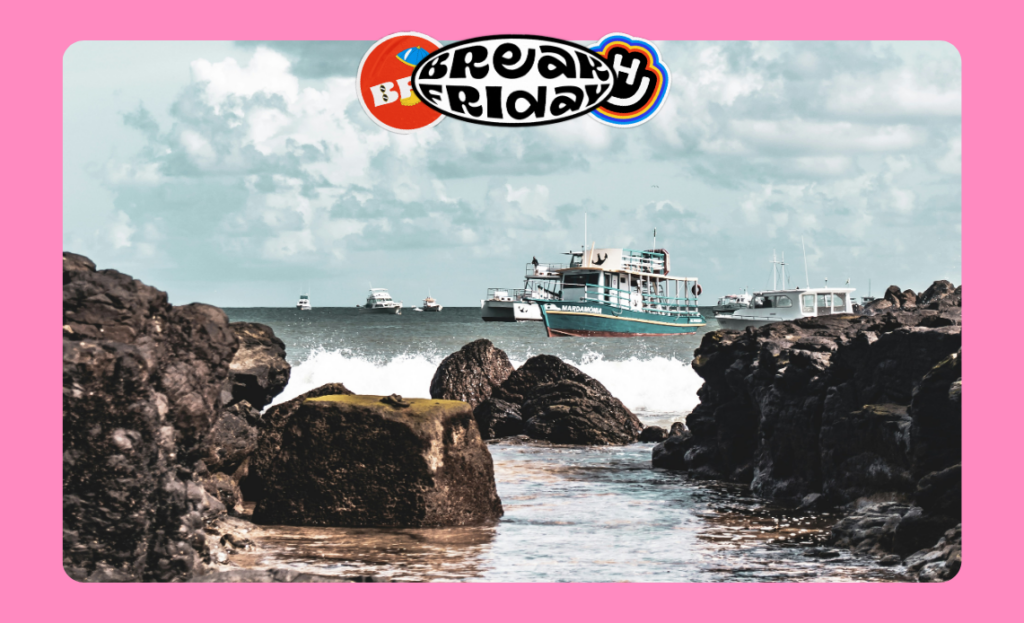 Embarcações no mar em Fernando de Noronha, Pernambuco, entre formações rochosas e céu parcialmente nublado.