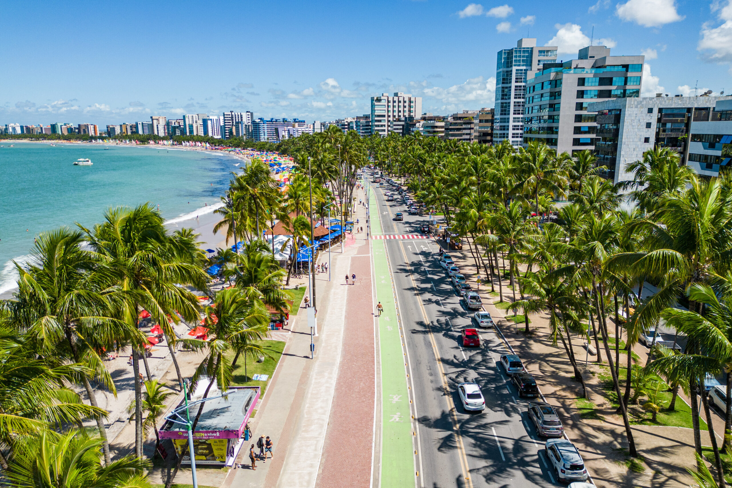 Orla da Praia de Ponta Verde, em Maceió, com calçadão, ciclovia e coqueiros ao longo da costa.