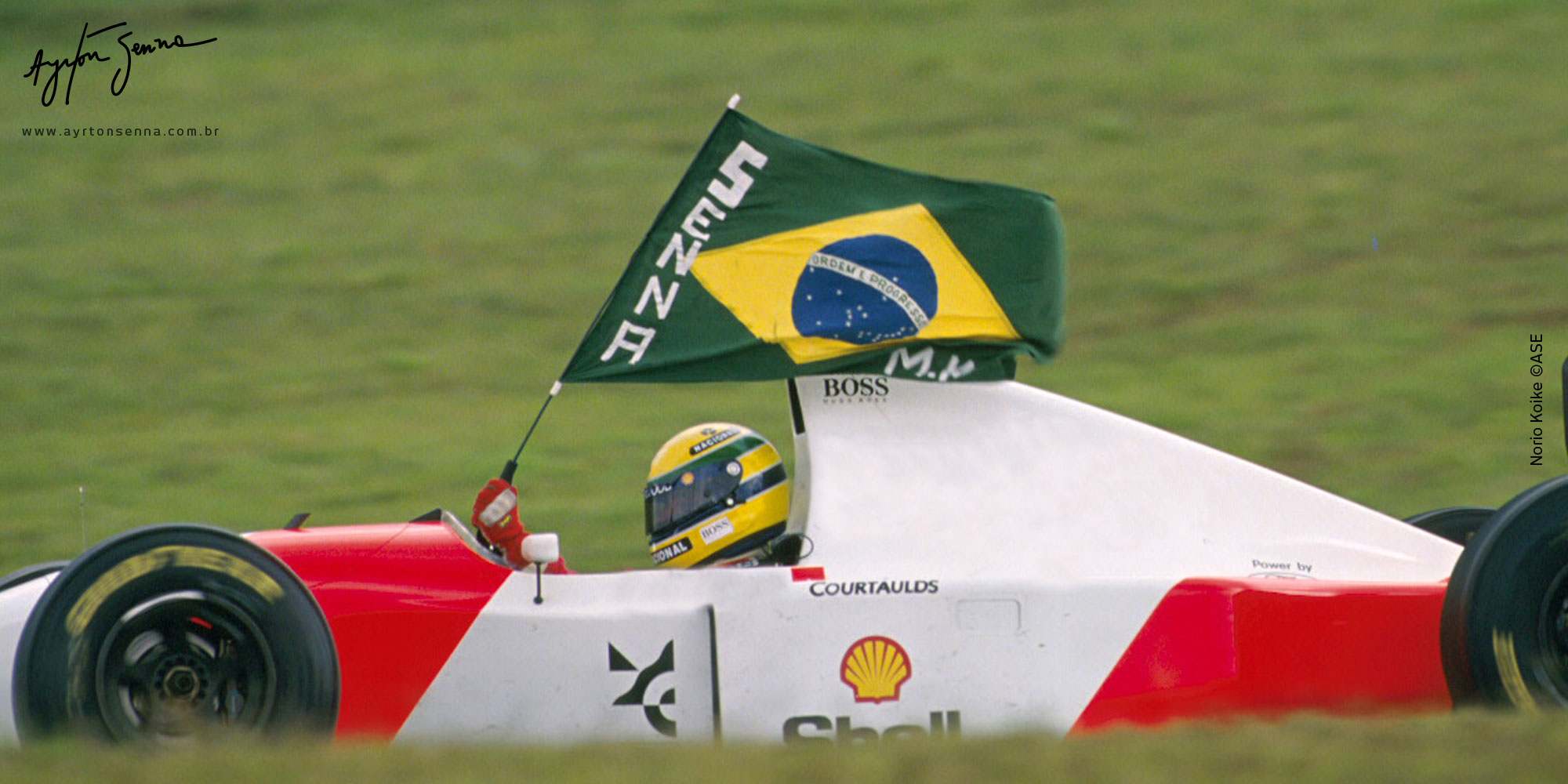 Ayrton Senna celebra com a bandeira do Brasil após vencer o GP do Brasil em seu icônico carro de Fórmula 1.