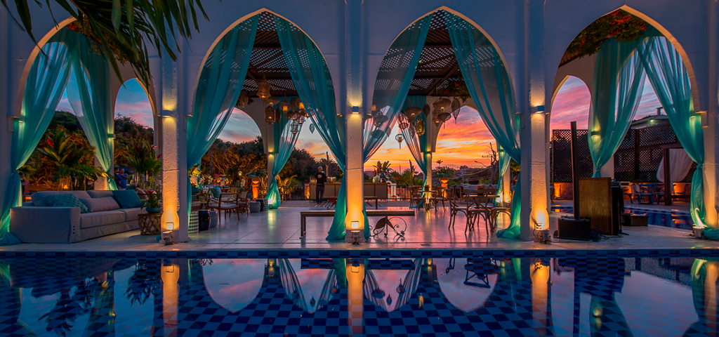 Ambiente sofisticado e relaxante no Pedra da Laguna Boutique Hotel & SPA em Búzios, com piscina refletindo luzes e cortinas elegantes.