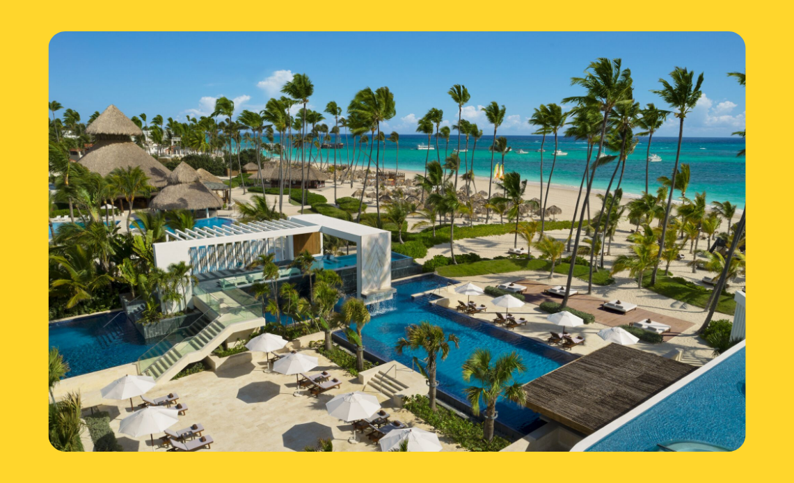 Vista aérea de um luxuoso resort all inclusive em Punta Cana, Caribe, com piscinas e acesso à praia paradisíaca.