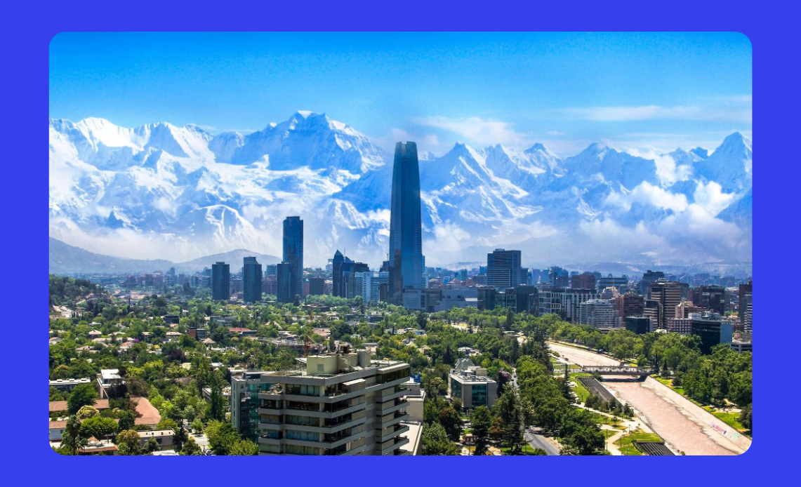 Vista panorâmica de Santiago, Chile, com a Cordilheira dos Andes ao fundo e prédios modernos em destaque.