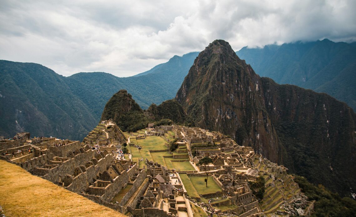 Vista aérea das ruínas de Machu Picchu, com montanhas ao fundo, representando cidades históricas que desapareceram.