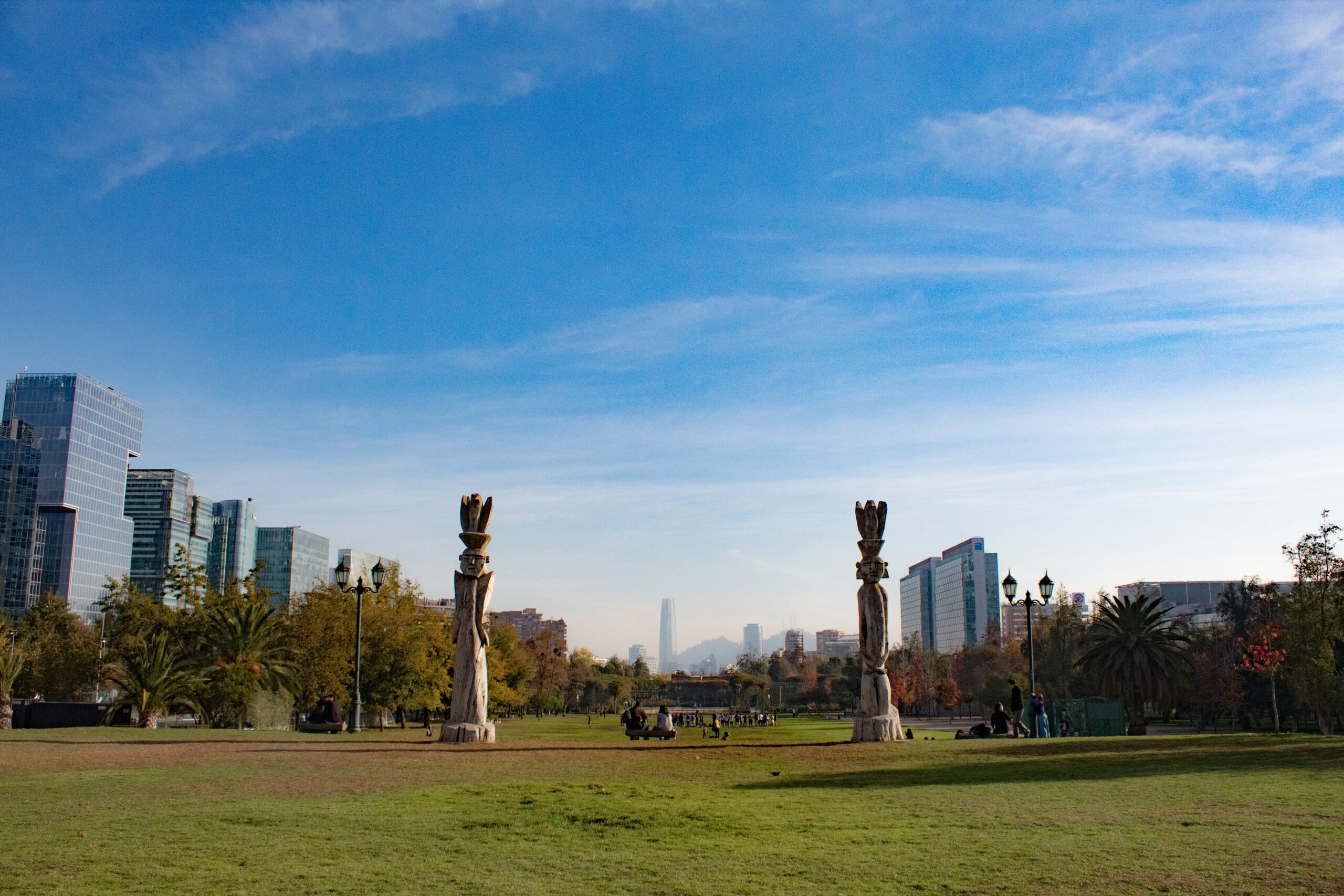 Vista do Parque Bicentenário em Las Condes, Santiago, Chile, com esculturas e prédios modernos ao fundo.