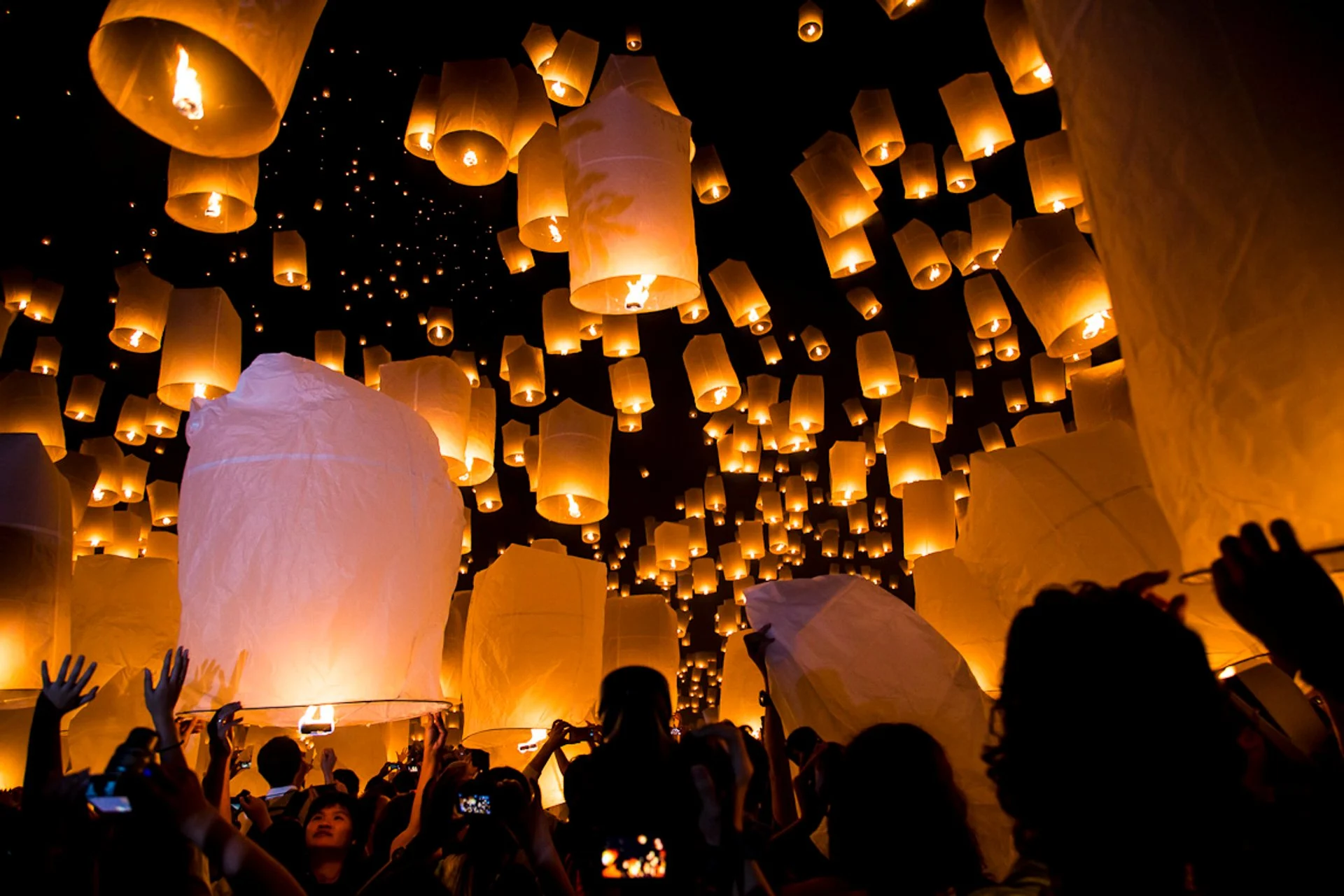 Lanternas flutuantes iluminam o céu noturno durante o Festival das Luzes em Chiang Mai, Tailândia.