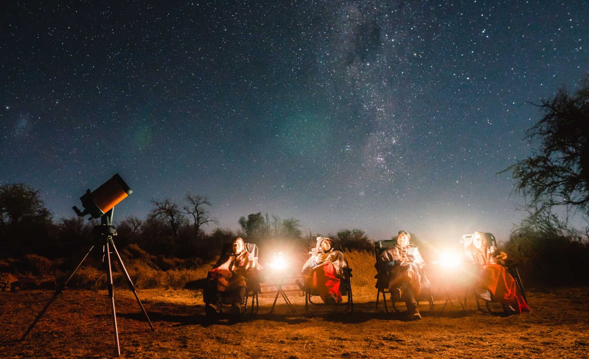 Pessoas observando o céu estrelado com telescópio em um tour de astroturismo na América Latina.